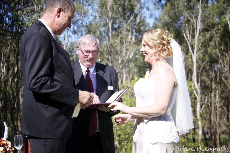 Groom putting ring on brides finger - wedding photography sydney